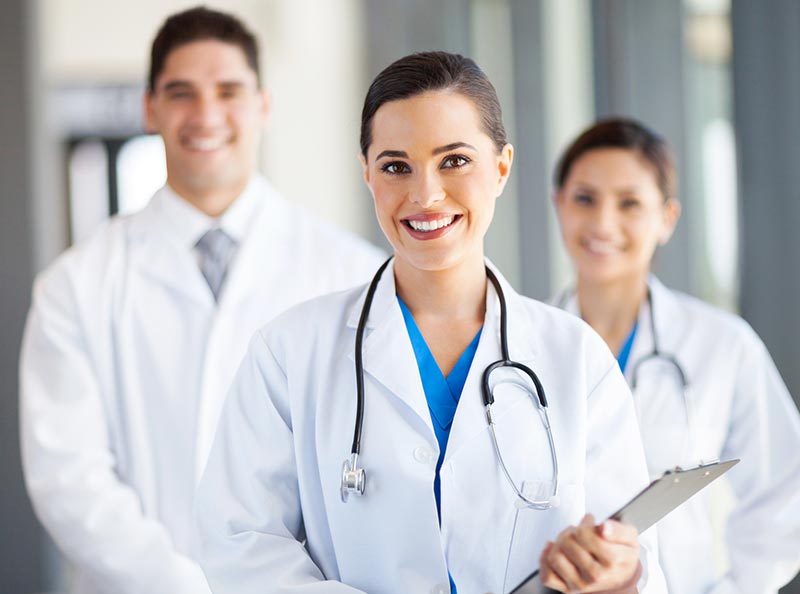 grupa trzech lekarzy w białych faruchach